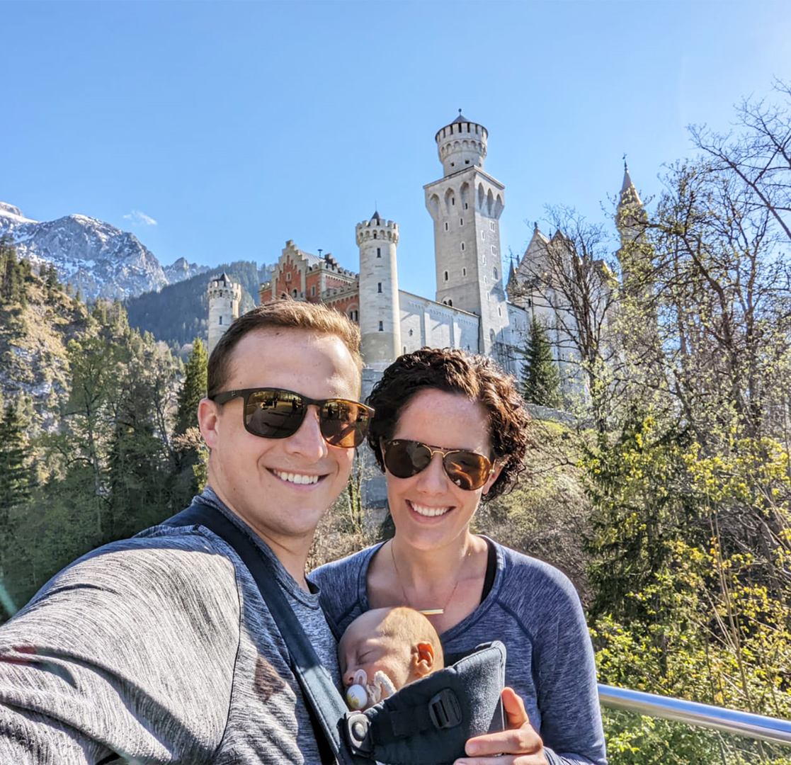 James and woman with baby, posing in front of castle.